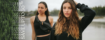 two women standing in front of a lake wearing sustainable clothing